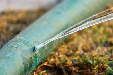 The pressure of the water in the hose causes the water to gush through the hole at a high velocity &mdash; pressure energy is converted into kinetic energy. (Source: &copy; toa555 / stock.adobe.com)
